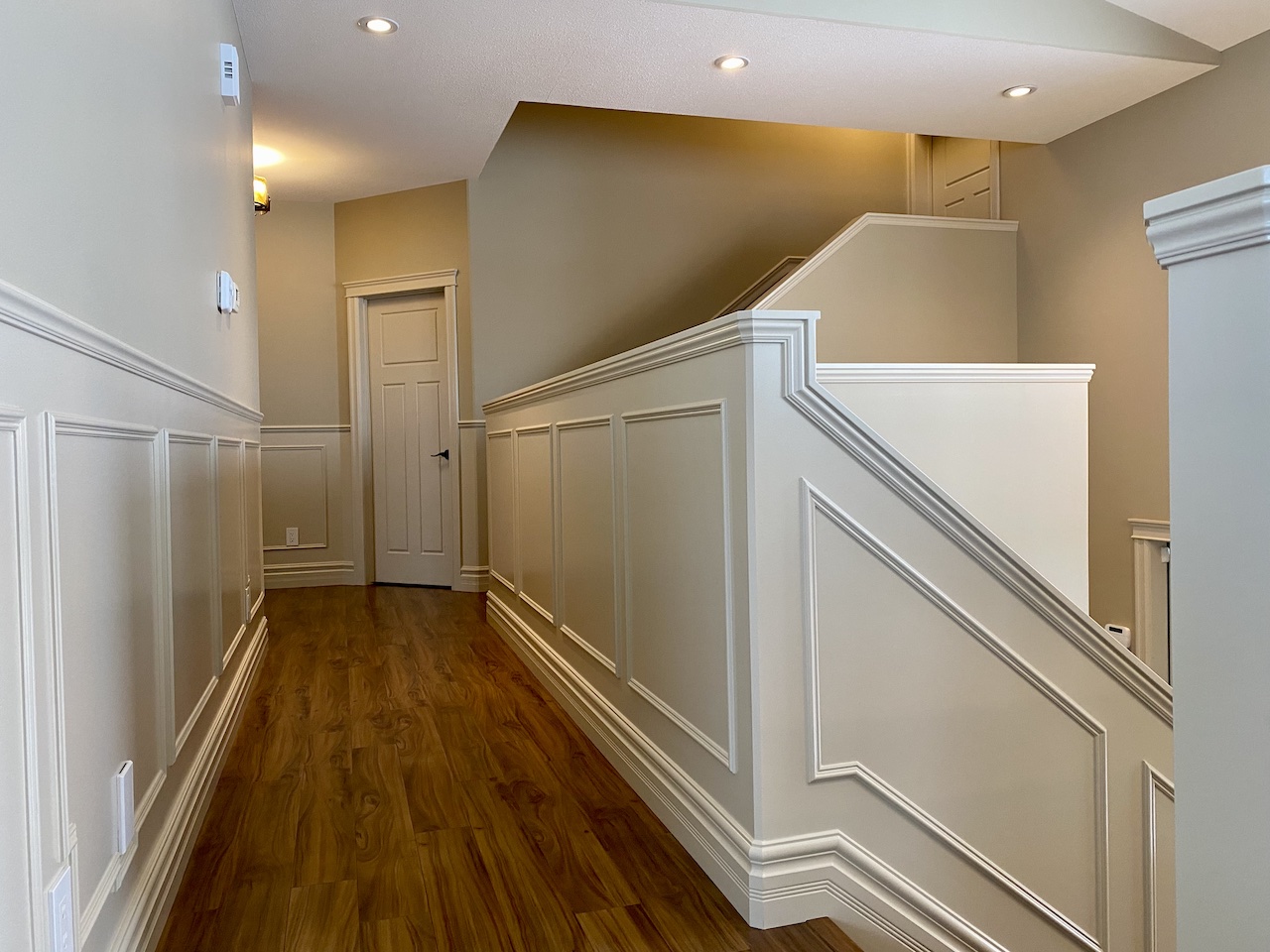 axium-interiors-finishing-carpentry-saskatoon-bergheim-acreage-IMG_5333-custom-trim-wainscotting-finishing-carpentry Walkout basement with dark cabinetry and gold accents, bright and spacious with floor to ceiling windows